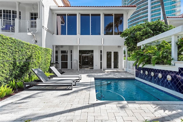 view of swimming pool featuring french doors and a patio area