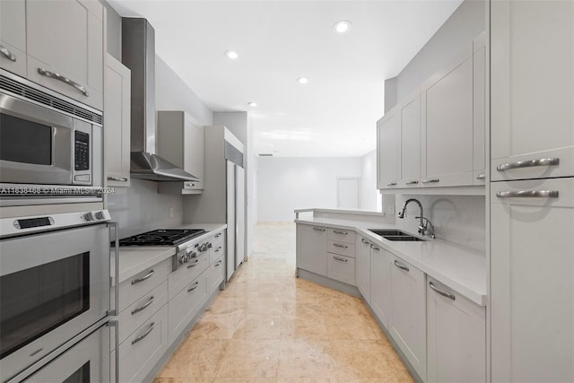 kitchen with stainless steel appliances, wall chimney exhaust hood, and sink