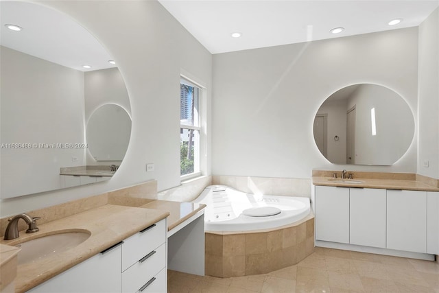 bathroom featuring tiled tub, vanity, and tile patterned floors