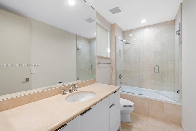 full bathroom featuring tile patterned floors, bath / shower combo with glass door, vanity, and toilet