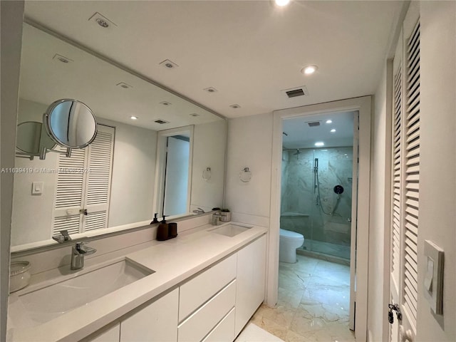 bathroom featuring a shower with shower door, tile patterned floors, double vanity, and toilet