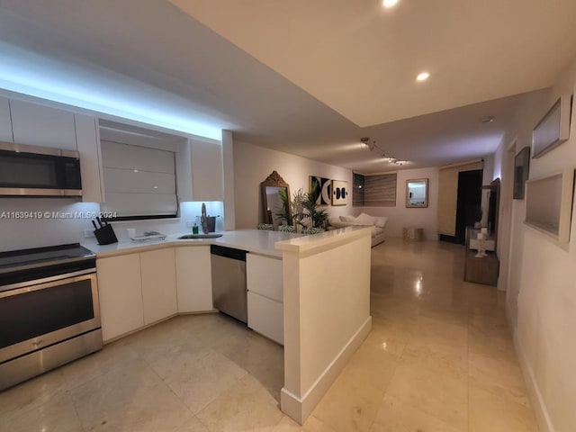 kitchen with light tile patterned flooring, white cabinets, stainless steel appliances, and kitchen peninsula