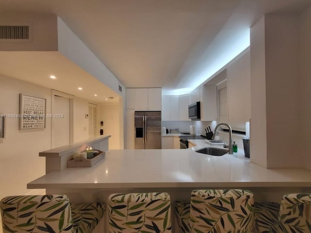 55 Ocean Lane Dr Unit 2030, Key Biscayne, FL 33149 - kitchen with stainless steel appliances, a sink, a kitchen breakfast bar, white cabinetry, and light countertops