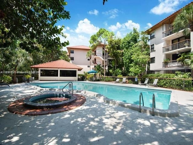 view of pool with a patio and a hot tub