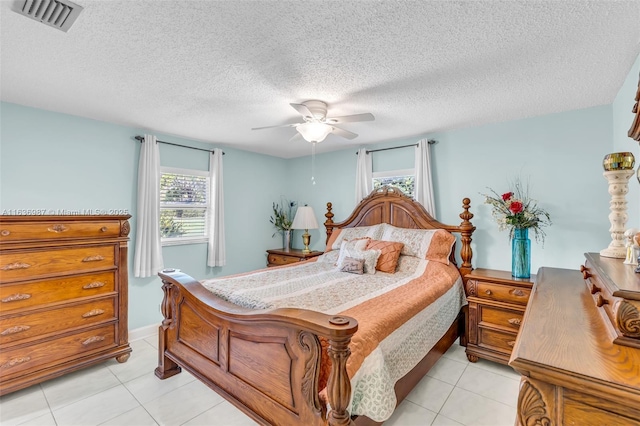 tiled bedroom with a textured ceiling and ceiling fan