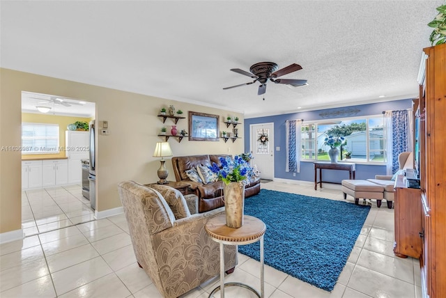 tiled living room featuring ceiling fan and a textured ceiling