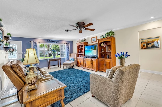 tiled living room with a textured ceiling, ceiling fan, and ornamental molding