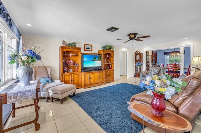 living room featuring a textured ceiling, crown molding, light tile patterned flooring, and ceiling fan with notable chandelier