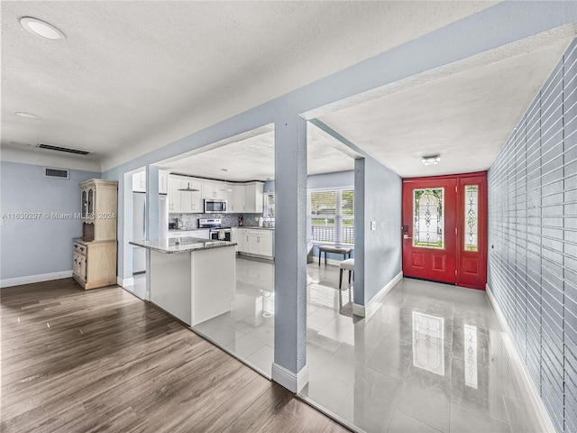 foyer featuring a textured ceiling and light wood-type flooring