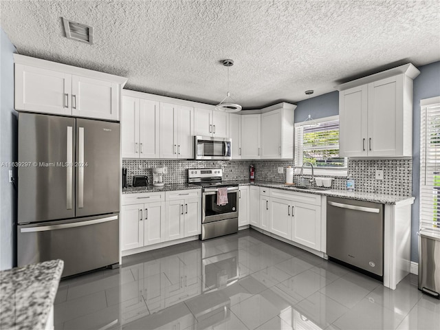 kitchen featuring white cabinets, backsplash, and stainless steel appliances