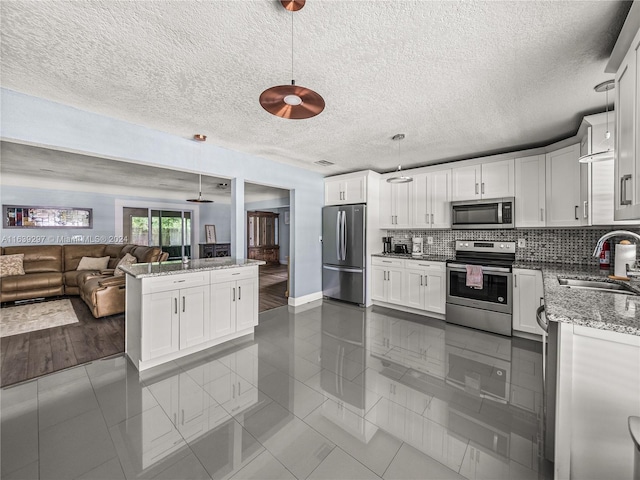 kitchen featuring a textured ceiling, stainless steel appliances, white cabinetry, sink, and dark hardwood / wood-style floors