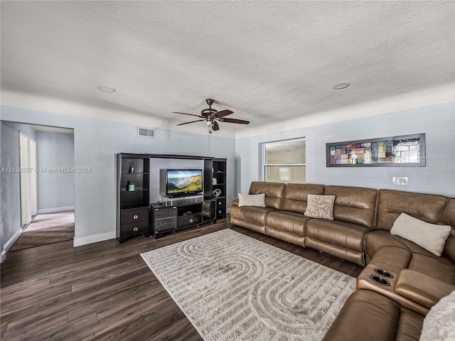 living room featuring a textured ceiling, dark hardwood / wood-style flooring, and ceiling fan