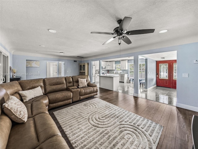 tiled living room featuring ceiling fan and a textured ceiling