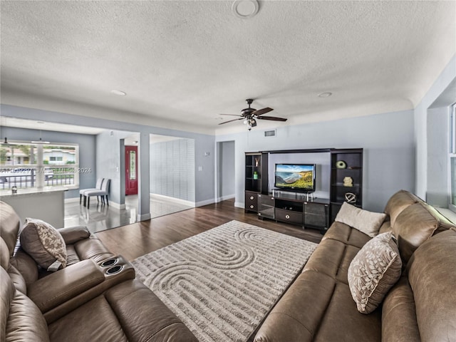 living room featuring ceiling fan, a textured ceiling, and hardwood / wood-style floors