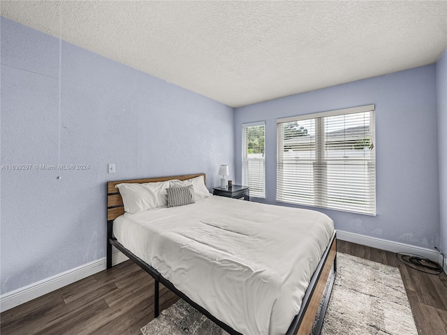 bedroom featuring a textured ceiling and dark wood-type flooring