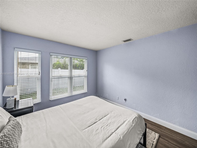 bedroom featuring wood-type flooring and a textured ceiling