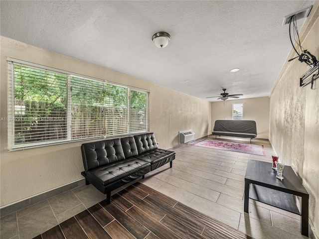 interior space with ceiling fan, dark wood-type flooring, and a textured ceiling