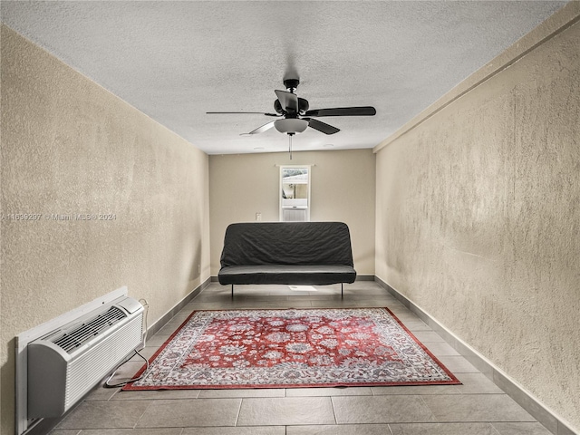 sitting room with ceiling fan, a textured ceiling, and light tile patterned floors