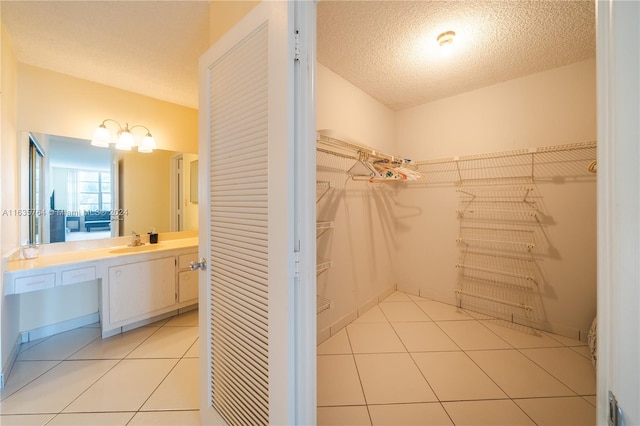 bathroom featuring vanity, a textured ceiling, and tile patterned flooring