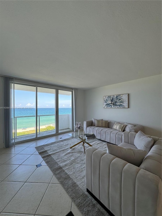 9195 Collins Ave Unit 801, Surfside, FL 33154 - living room featuring a water view, a textured ceiling, and light tile patterned flooring
