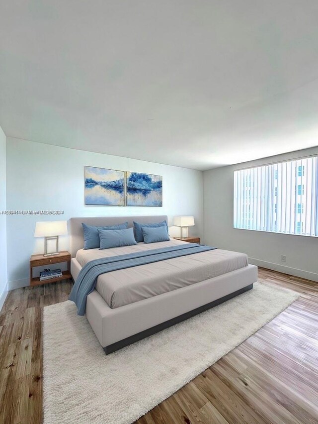 9195 Collins Ave Unit 801, Surfside, FL 33154 - bedroom featuring baseboards and wood finished floors