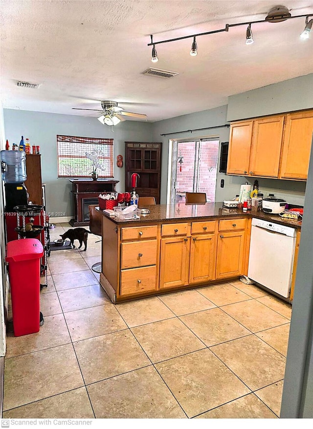 kitchen with a textured ceiling, light tile patterned flooring, dishwasher, ceiling fan, and kitchen peninsula