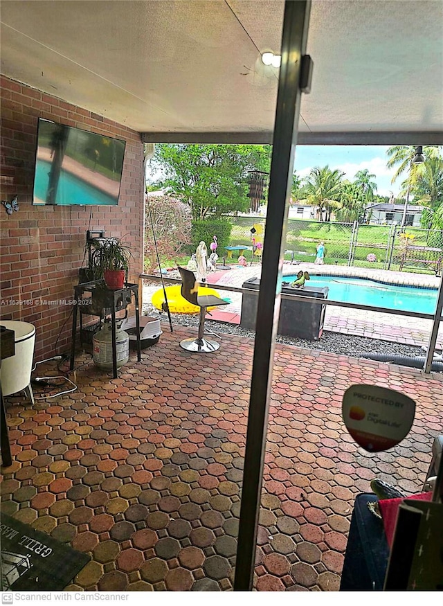 view of patio featuring glass enclosure