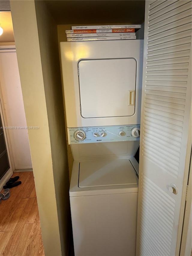 washroom with stacked washer and dryer and light wood-type flooring