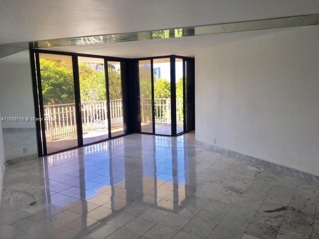 empty room featuring a wall of windows and french doors