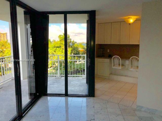 entryway with a wall of windows and light tile patterned floors