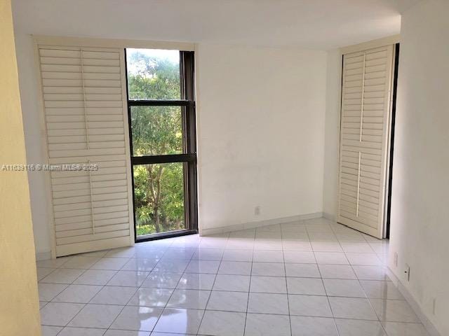 unfurnished room with plenty of natural light and light tile patterned flooring