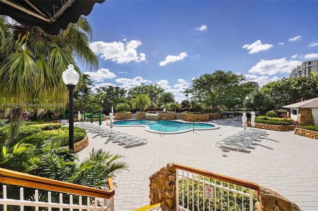 view of swimming pool featuring pool water feature and a patio area