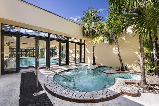 view of pool featuring a jacuzzi and a patio