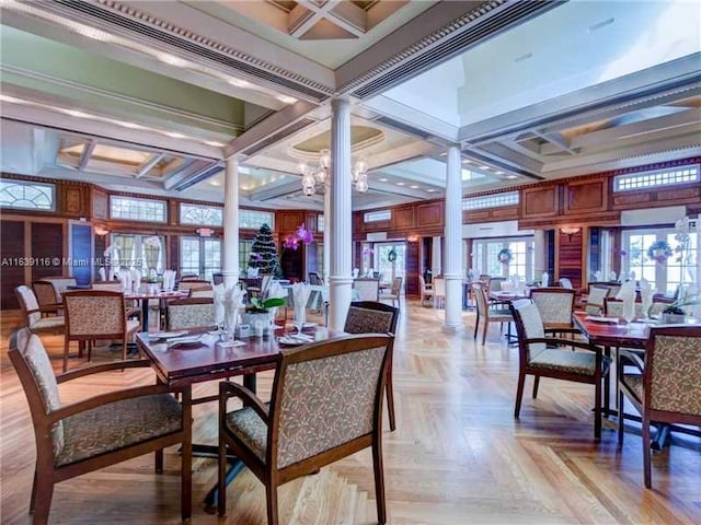 dining space featuring ornate columns, coffered ceiling, a notable chandelier, light parquet flooring, and beamed ceiling