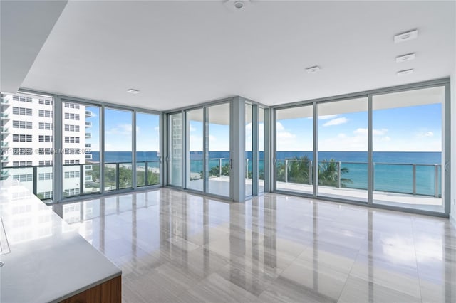 interior space with a water view, plenty of natural light, and expansive windows