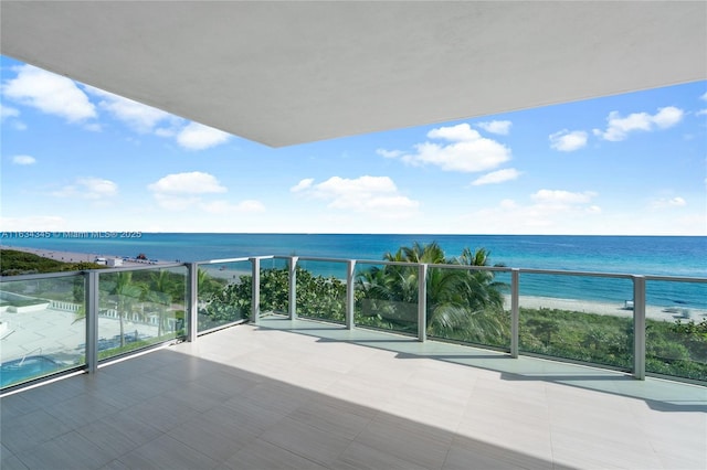 balcony featuring a water view and a view of the beach