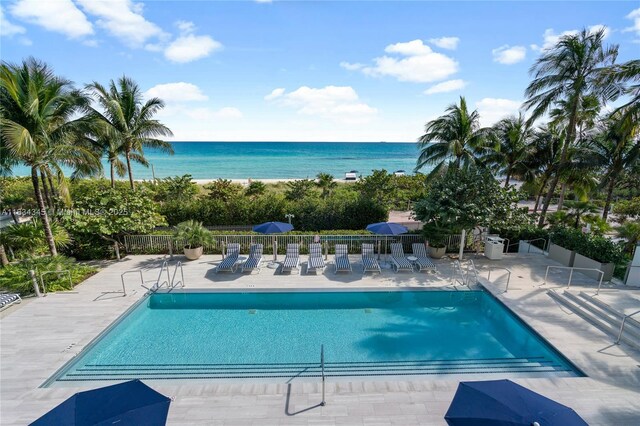 view of swimming pool with a water view and a patio