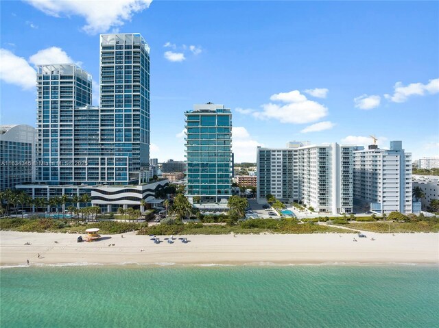 property's view of city featuring a water view and a beach view