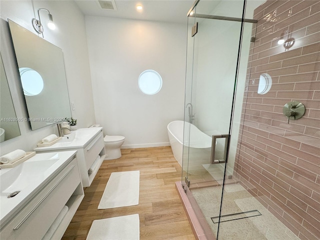 full bathroom with vanity, separate shower and tub, hardwood / wood-style floors, and toilet