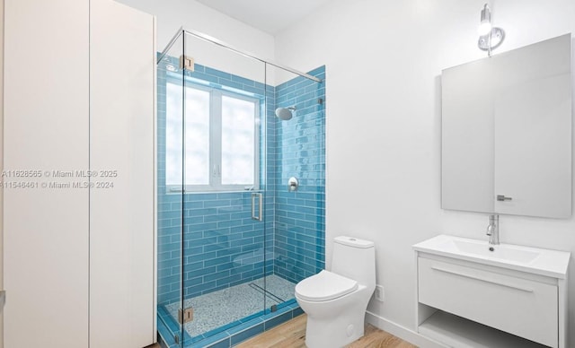 bathroom featuring walk in shower, vanity, toilet, and hardwood / wood-style floors