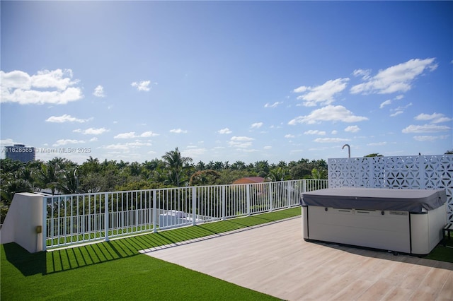 deck featuring a yard and a hot tub