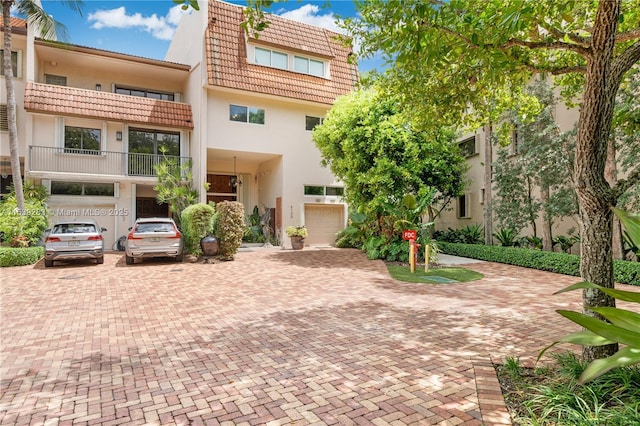 townhome / multi-family property with a tiled roof and stucco siding