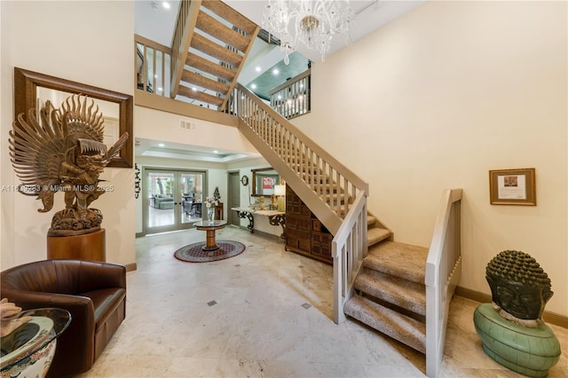 entryway featuring a notable chandelier, a towering ceiling, visible vents, french doors, and stairway