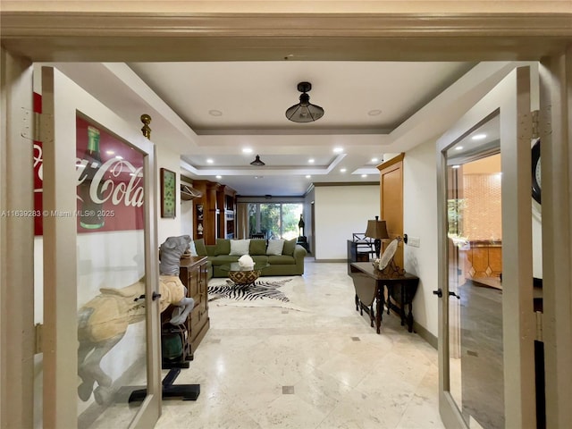 corridor with recessed lighting, baseboards, a raised ceiling, and french doors