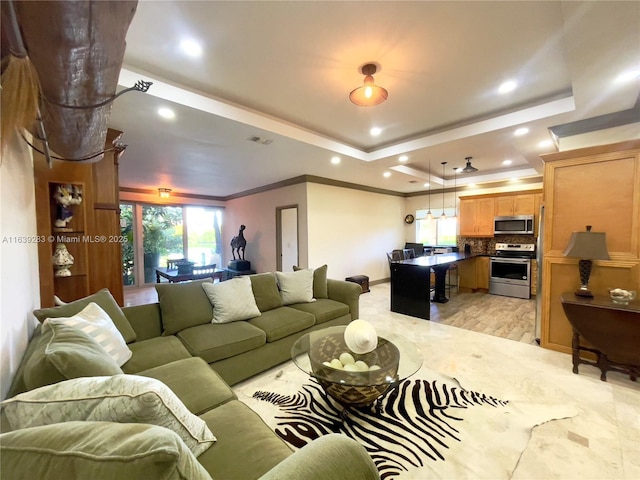 living area with a tray ceiling, recessed lighting, visible vents, and crown molding