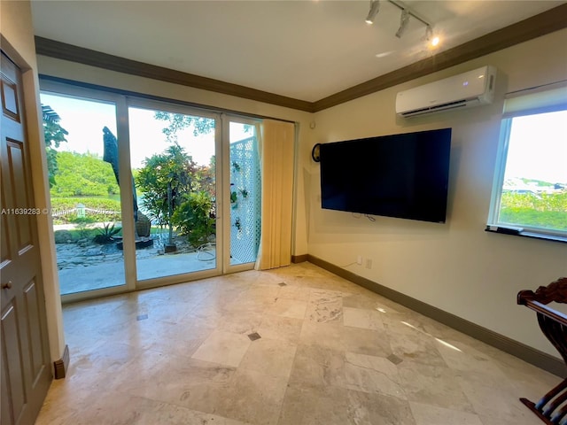 interior space with baseboards, ornamental molding, track lighting, and a wall mounted air conditioner