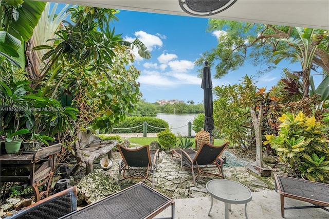 view of patio / terrace with a water view and fence