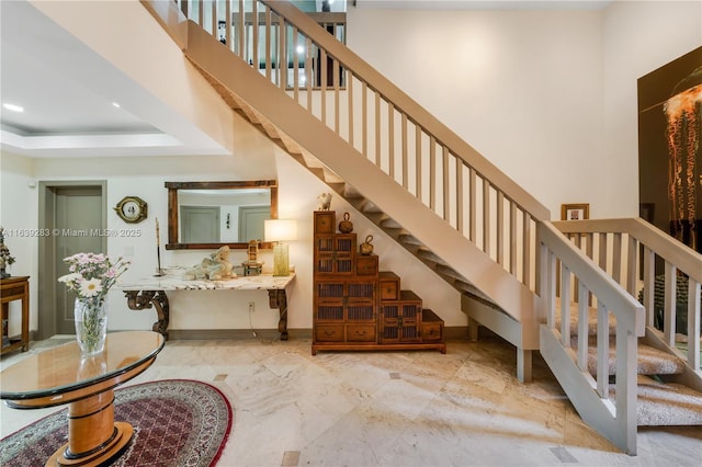 stairs with recessed lighting, a towering ceiling, and baseboards