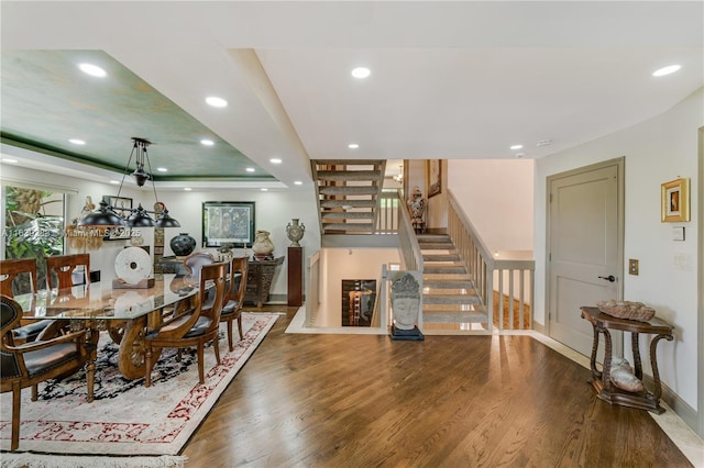 dining area with baseboards, a raised ceiling, stairway, wood finished floors, and recessed lighting