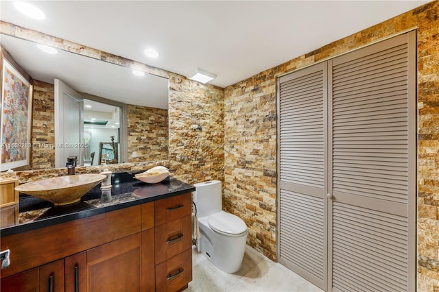 bathroom featuring toilet, a closet, and vanity